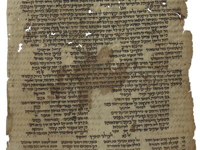 Damaged manuscript page with Hebrew script arranged variously in paragraphs and columns, mostly in black ink with some in brown, with holes obscuring some of the text.
