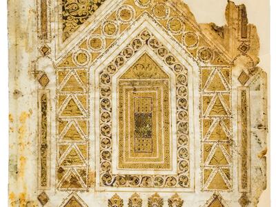 Damaged manuscript page with intricate gold and brown geometric and floral designs forming a house shape, featuring geometric and floral patterns, with Hebrew micrography.