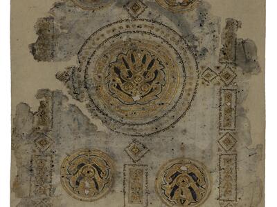 Fragment of damaged parchment featuring ornate geometric and floral designs in gold and black, including one large and two small circular lotuses and Hebrew micrography.