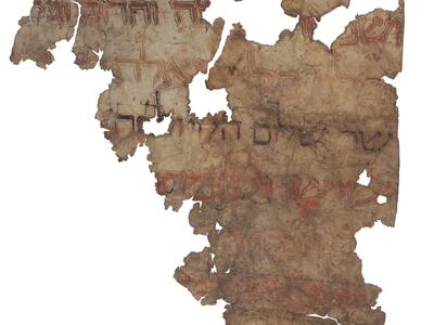 Damaged parchment fragment with faded Hebrew script in gold, red, and black with decorations and contrasting outlines.