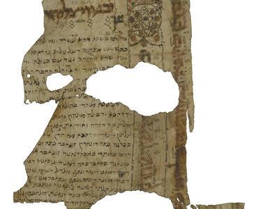 Damaged manuscript fragment with colorful Hebrew text and geometric, floral, and micrographic decorations, including nested six-pointed stars.