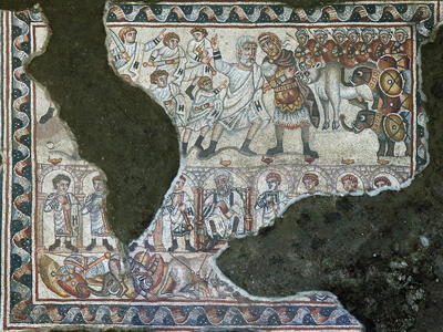 Ancient mosaic depicting armed soldiers, a group of robed figures, and battle elephants, surrounded by a decorative border. Some details are obscured by damage.