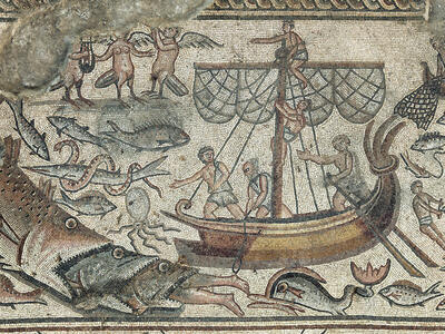 Ancient mosaic depicting a ship surrounded by sea creatures, including large fish, with sailors on board and figures in the water; some mythological beings and decorative details are visible.