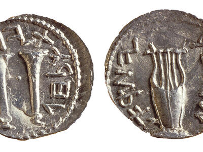 Two sides of an ancient silver coin, each with Paleo-Hebrew inscriptions around the edges. One side shows two trumpets, and the other side shows a lyre.