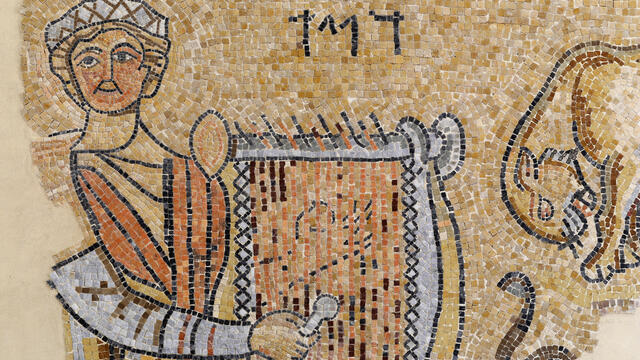 Ancient mosaic showing a person in a robe holding a lyre, with Hebrew letters above and part of an animal figure on the right side.