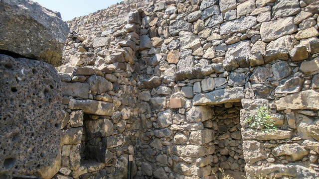 Two stone walls with niches meeting at a corner.