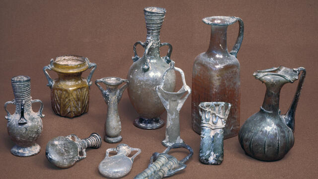 A collection of ancient glass vessels in various shapes and sizes.