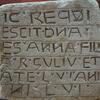 Upright stone slab engraved with ten rows of vowelless Hebrew roughly inscribed and separated by lines.