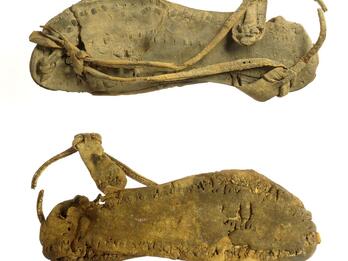 Two views of a single leather sandal. 