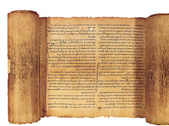Partially unrolled scroll with page of Hebrew writing visible.