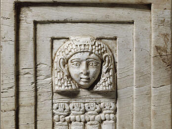 Ivory Relief of a Woman at a Window Rectangular relief of face framed in rectangular layers and four small columns below.