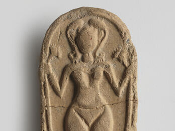 Figurine of Female Deity Oval clay piece with figurine of naked woman decorated with headdress, necklace, bracelets, and anklets, and holding a lotus flower.