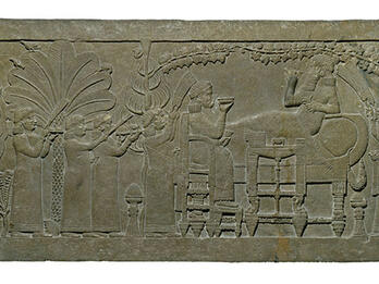 Assurbanipal Feasting in Palace Garden Relief of figure on chair and figure reclining on sofa, surrounded by foliage, as several smaller figures wave fans, carry platters, and play instruments.