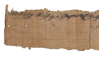 Long and narrow papyrus fragment with Hebrew writing on top. 