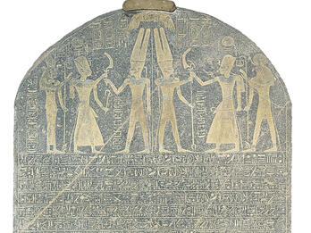 Stone with rounded top with drawing of six figures wielding weapons and Egyptian hieroglyphic writing in rows.