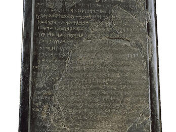 Stone with rounded top filled with Phoenician writing. 