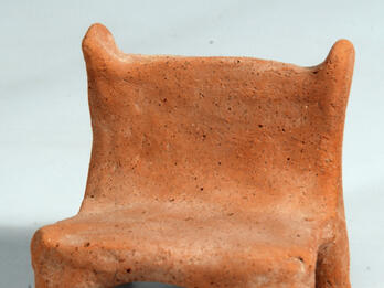 Model Chair Terra-cotta chair with four short legs.