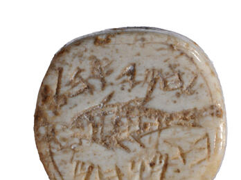 Seal of Hamiohel Daughter of Menahem, with Fish Seal made of bone and decorated with a fish and a Hebrew inscription.
