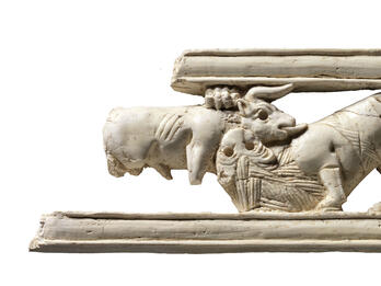 Ivory-openwork Panel with a Battle between a Wild Bull and a Lion Ivory carving of a sphinx amid lotus flowers.