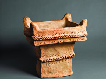 Small Ceramic Altar from Hazor Square ceramic altar with recessed offering surface decorated with crosshatching and circles and horns on four upper corners.