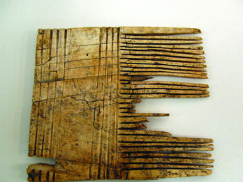 Bone Comb Square-shaped comb with closely-positioned teeth on the right-hand side and wide handle with carved stripes.