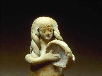 Woman Playing Frame Drum Terra-cotta figurine of women with long hair playing frame drum.
