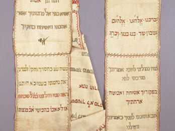 Linen Torah Binder Rectangular cloth arranged in two columns embroidered with Hebrew text and small Star of David on right side.