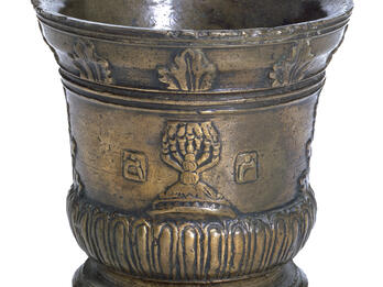 Bronze mortar decorated with a seven-branched candelabrum, flanked with the Hebrew letters mem and resh.