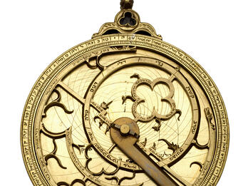 Watch-like device with concentric circles, inner geometric shapes and hands.