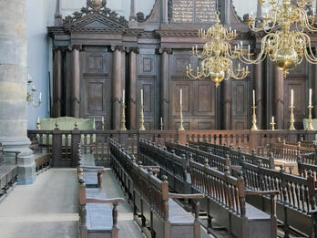 Photograph of room with wooden pews.
