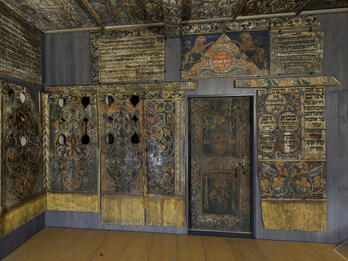 Private Synagogue, Unterlimpurg, Germany Photograph of room with wood walls painted with Hebrew text, animals, and floral designs.