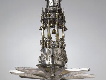 Silver multi-tiered hanging lamp with sculpture of lion on top. 