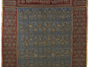 Torah Ark Curtain Cloth embroidered with floral border, Hebrew text across the top, and repeating motif in center.