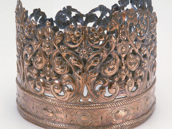 Crown with decoration above rim. 