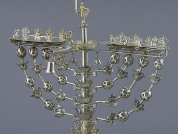 Eight-branched candelabrum with figure on top brandishing sword.