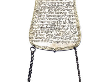 Plaque with Hebrew text and two chains hanging from the bottom.
