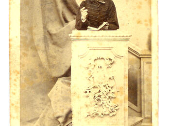 Ignác Goldziher Speaking at His Bar Mitzvah, 1863 Photograph of young man wearing a hat and standing behind a podium.