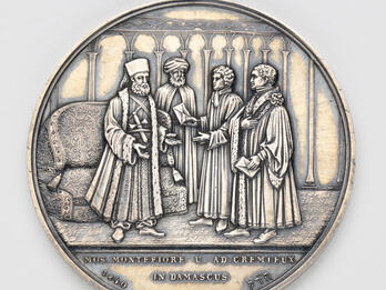 Silver medal depicting four men talking.
