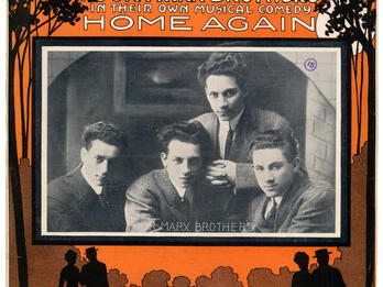 Home Again Page with English text on top and bottom with center photograph of four men, and silhouettes of two couples on the bottom.