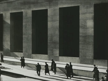 Wall Street Photograph of silhouetted men walking next to high-columned building.