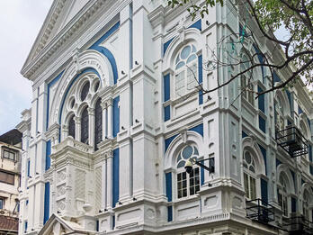 Keneseth Eliyahoo Synagogue Photograph of building façade with significant decorative trim on window frames and beams.