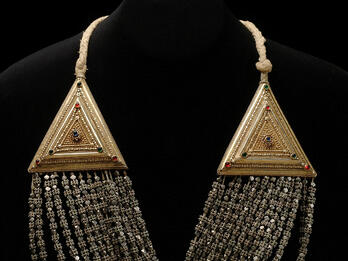 Necklace with triangular settings on either side, with strings of beads running between them.