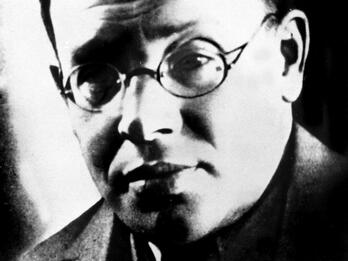 Isaac Babel Photograph of man wearing glasses and suit.