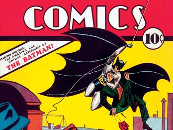 Detective Comics, May 1939: The Amazing and Unique Adventures of the Batman, cover Cover page of comic featuring man with bat wings outstretched swinging through the air over buildings with a villain under his arm as two detectives watch, and heading "Detective Comics" across the top.
