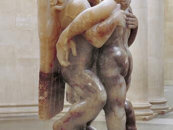 Jacob and the Angel Sculpture depicting angel and man, both upright, with arms around each other.