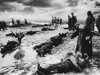 Kerch, Crimea (Grief) Photograph of people standing in a field upon which lie dead bodies.
