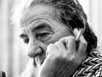 Golda Meir Photograph of an elderly woman smoking a cigarette, whose face is partially blocked by her hand holding the cigarette.