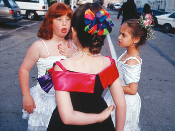 A Bat Mitzvah Party at the 20th Century Fox Movie Studio Commissary, West Los Angeles Three young girls wearing party dresses standing in a circle.