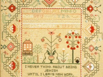 Decorative needlepoint of the alphabet and numbers featuring home, flowers, trees, birds, and English text: "I never think about being Jewish until I leave New York . . . Paul Tannenbaum."