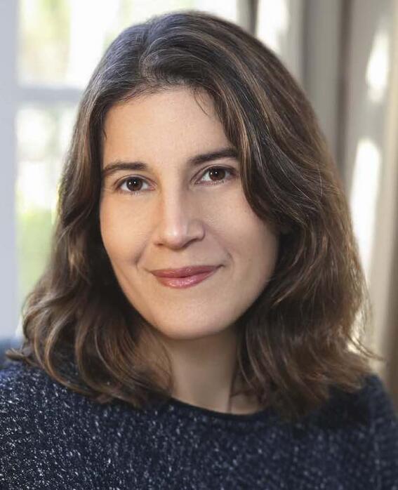 A smiling woman with shoulder-length brown hair and brown eyes looks at the camera.
